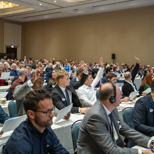 People Raising Hands in Conference